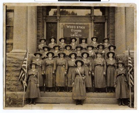 Women's organization, the Woodstock Guards of Loyalty, posing in uniform on the steps of the Pipestone County Courthouse