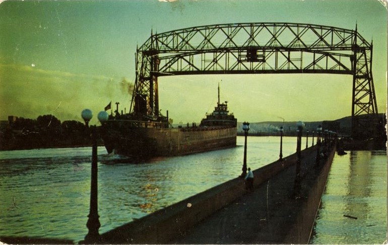 Path and ship leading to Duluth's aerial lift bridge while front of green sky