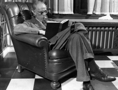 Sinclair Lewis reading a book in his chair, 1944
