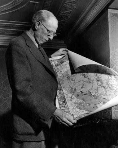 Sinclair Lewis examining a map of the Duluth area, 1944