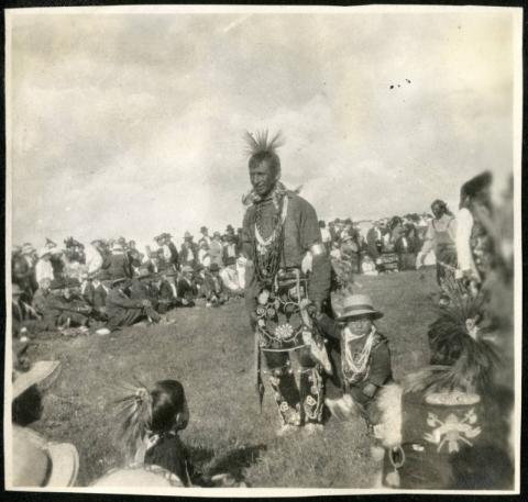 Ojibwe man and child dancing at a powwow