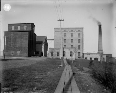 Two milling buildings beside a smokestack