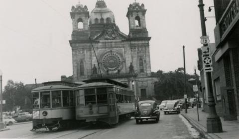 Street with cars and streetcars in front of the basilica