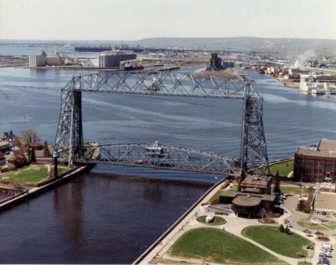 Far, overhead view of Duluth's lift bridge connecting to constructed-on lands. Behind is city