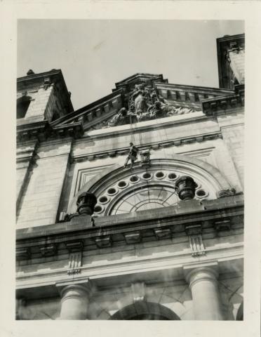 Upshot of basilica with man on pulley to clean exterior