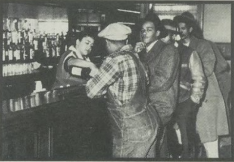 People stand at the bar at Jim's Place in Rondo