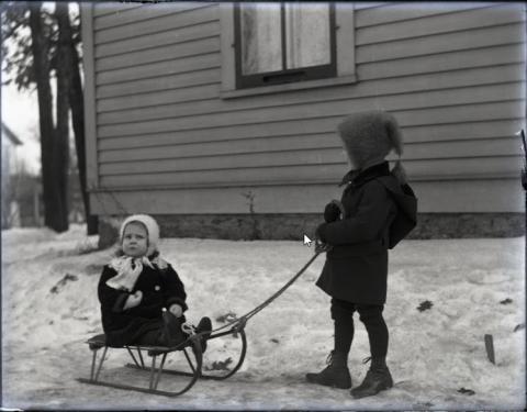 Portrait of Dwight and Inet Holcombe sledding, Stillwater, Minnesota