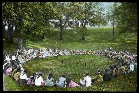 Girls seated in a circle at a park