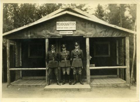Officers standing outside of work camp building in the woods