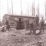 Family outside of a log cabin