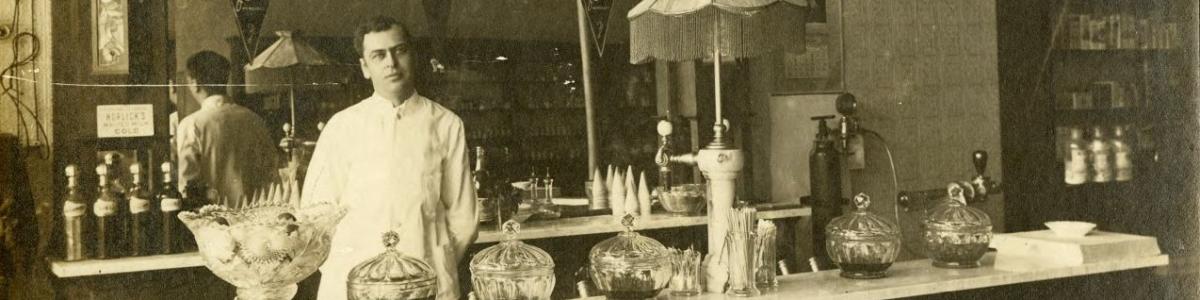E. H. Cormontan behind the counter in Cormonton's Drug Store, Fosston, Minnesota